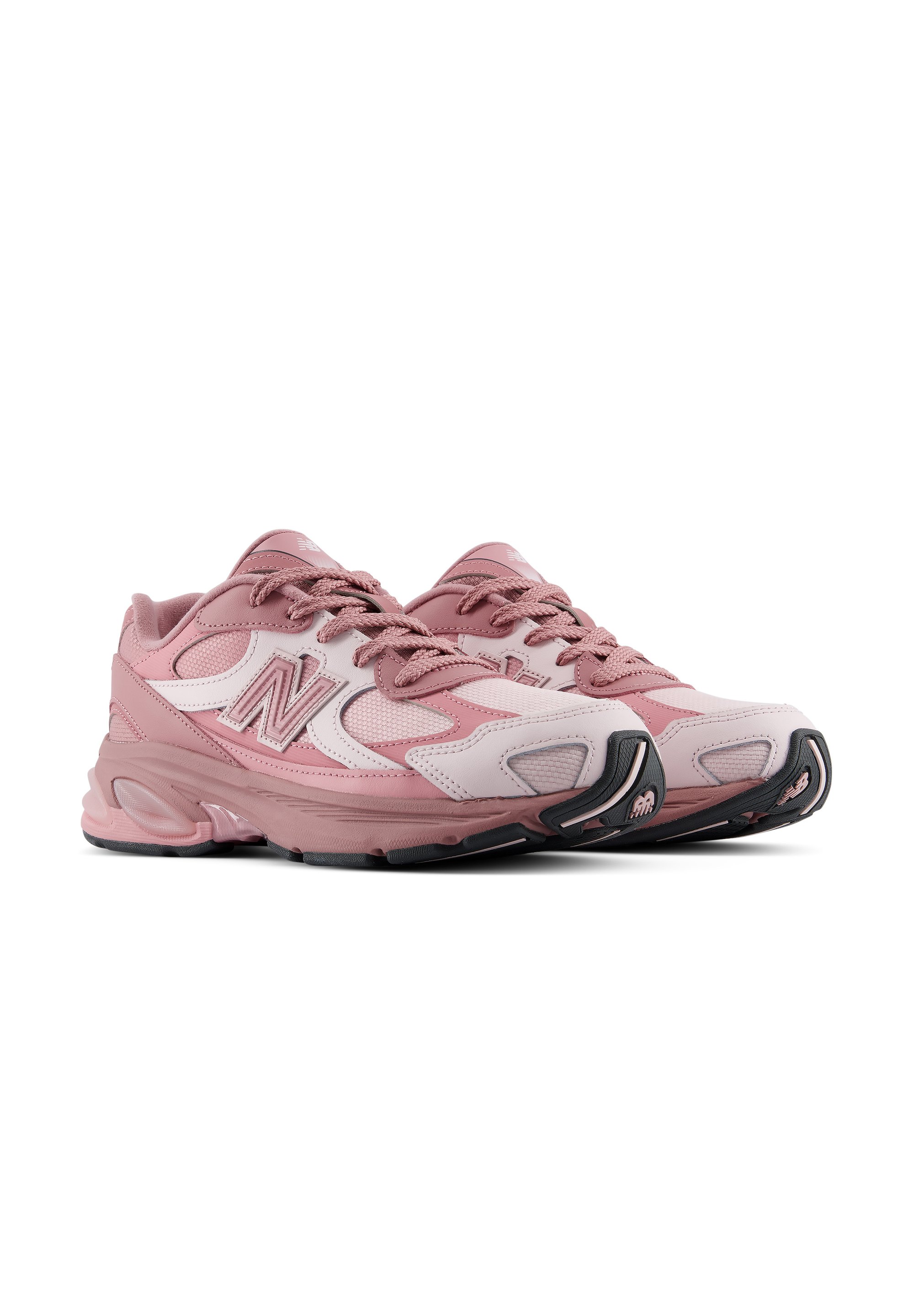 Par de zapatillas deportivas New Balance rosas y blancas con cordones sobre un fondo blanco, inclinadas para mostrar detalles laterales y frontales.