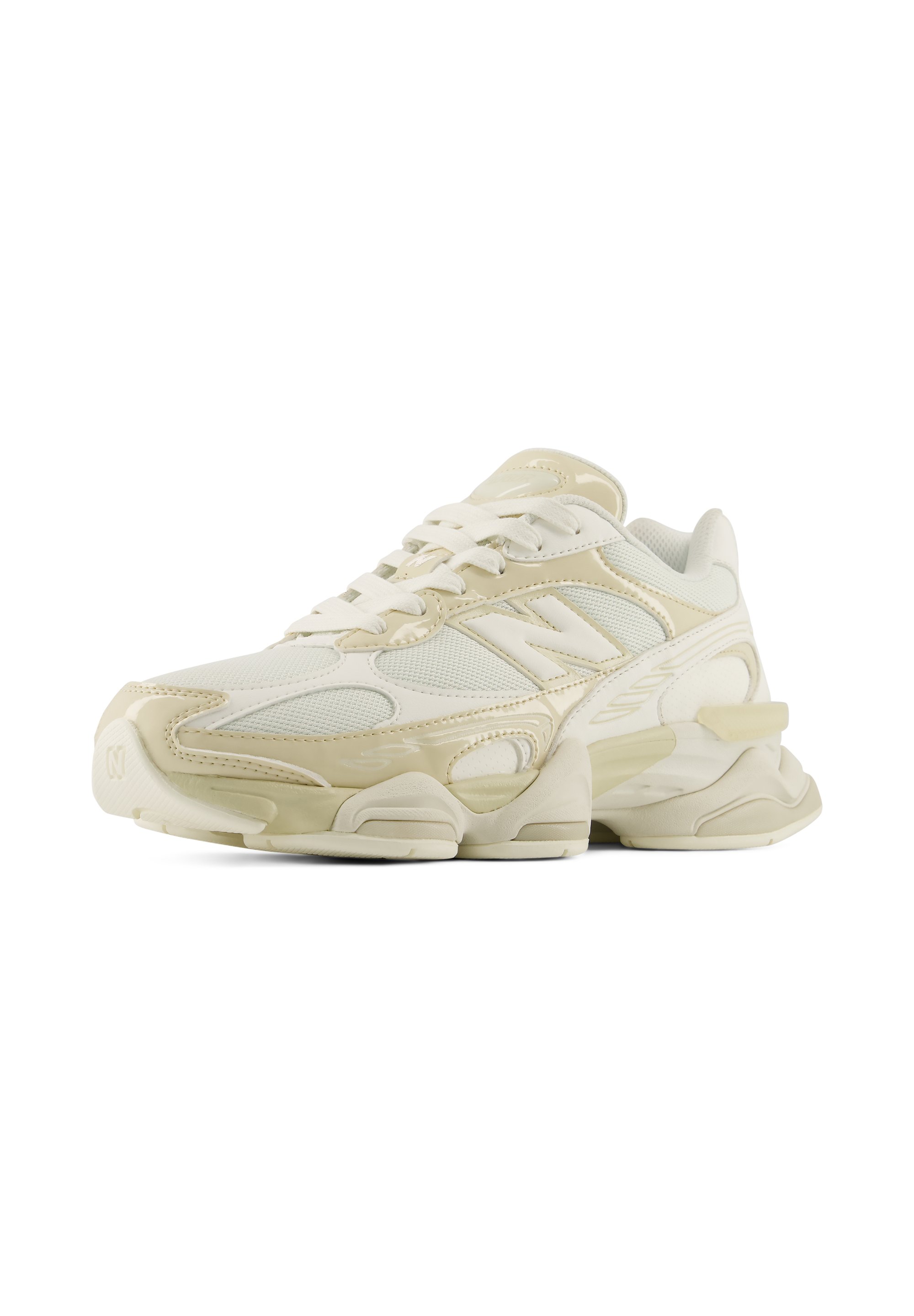 Zapatilla deportiva en crema y beige con paneles de malla y sintéticos, suela gruesa y cierre de cordones, mostrada desde un ángulo frontal lateral.