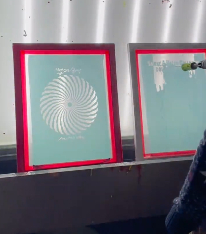 Rinsing an exposed screen at the washout booth (stencil washout).