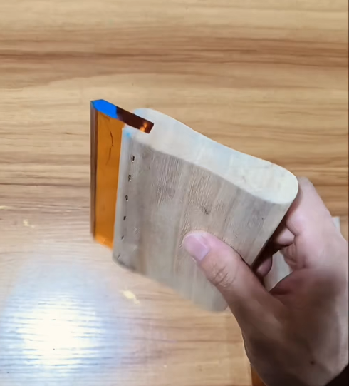 Screen printing squeegee close-up: wood handle and blade edge.
