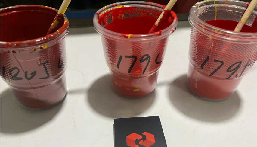 Screen printing ink test cups with mixed red ink.