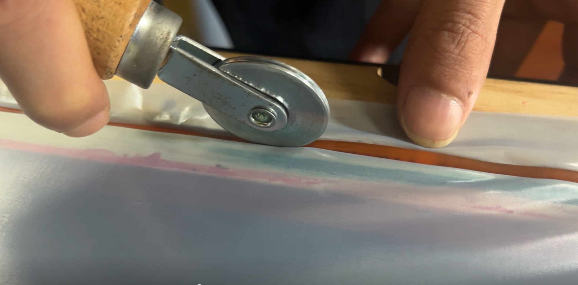 Using a hand roller to press the edges for a tight, wrinkle-free seal