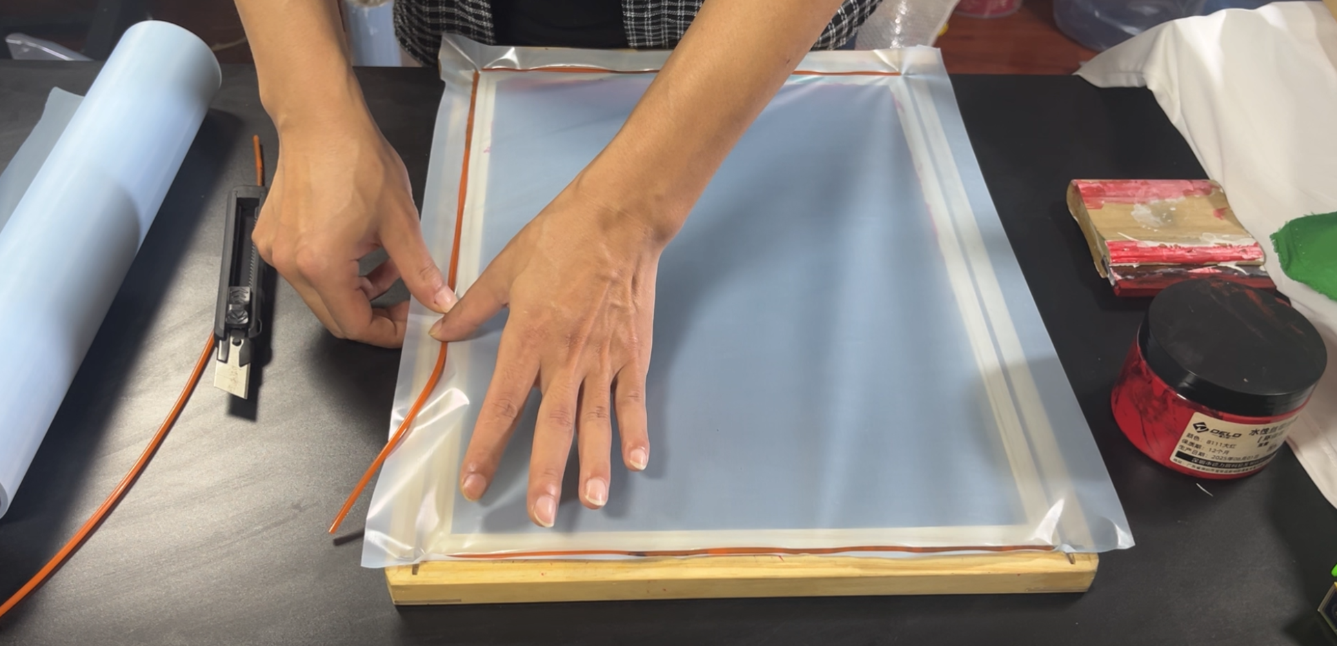 Using a hand roller to press the edges for a tight, wrinkle-free seal