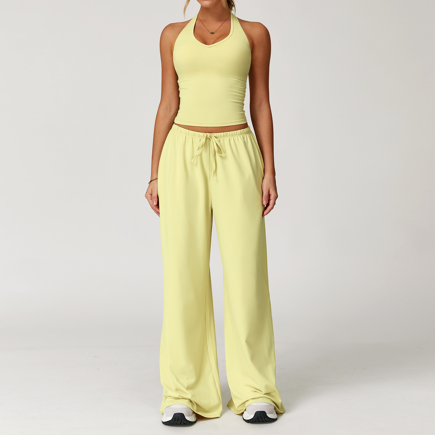 Women's Casual Sportswear Set — A slim-fitting, summer-style athletic outfit crafted from silky-feel polyester. It features an adjustable V-neck camisole paired with wide-leg trousers. Cool, quick-drying, and breathable, this set accentuates your alluring