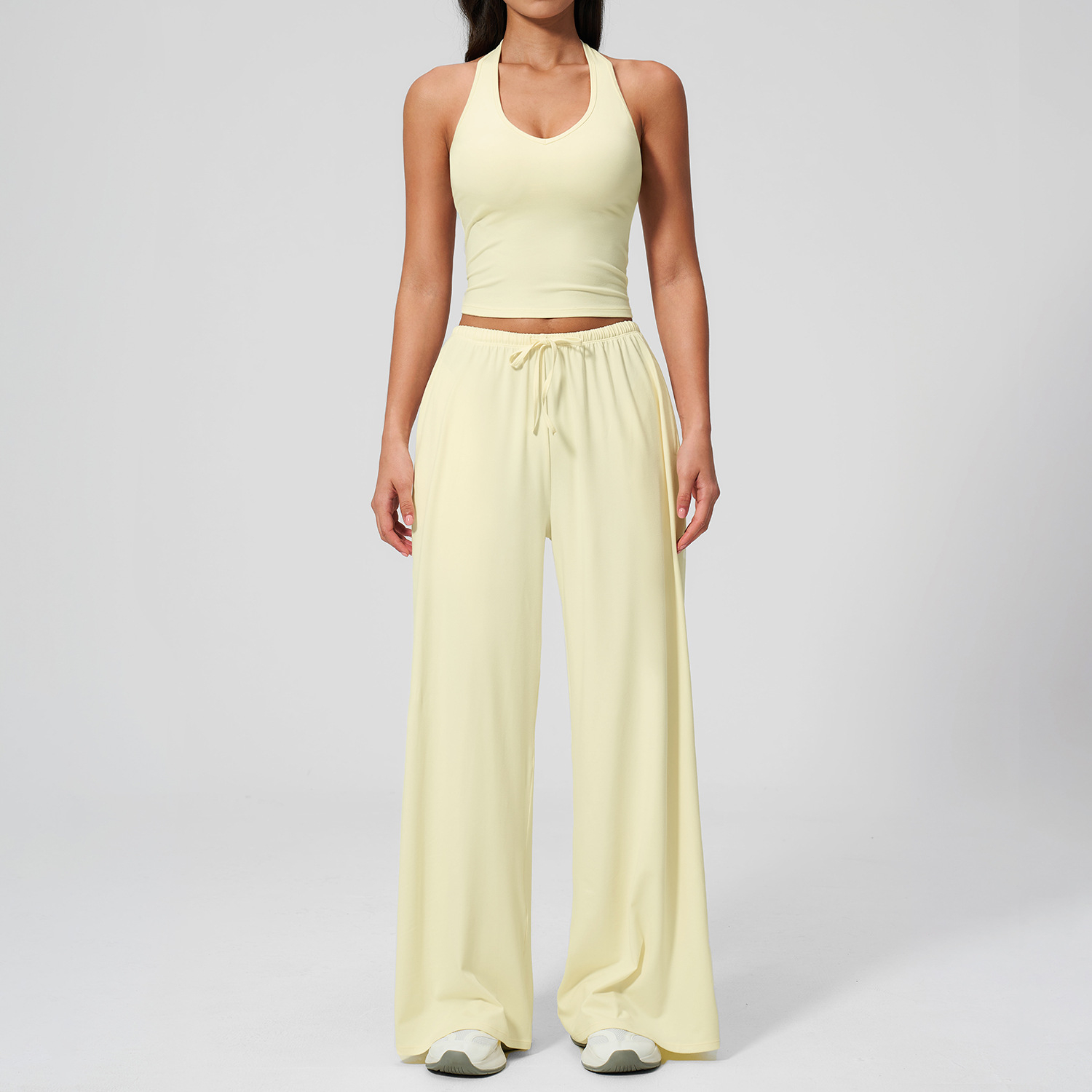 Women's Casual Sportswear Set — A slim-fitting, summer-style athletic outfit crafted from silky-feel polyester. It features an adjustable V-neck camisole paired with wide-leg trousers. Cool, quick-drying, and breathable, this set accentuates your alluring