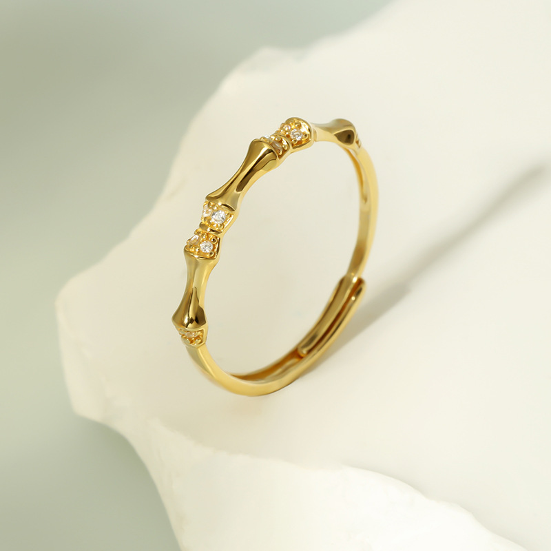Front view of Adjustable Bamboo Ring in Solid Silver with CZ on marble background