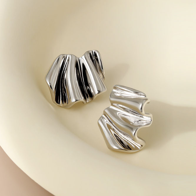 Front view of S925 Wavy Fold Earrings Rhodium Plated on marble background