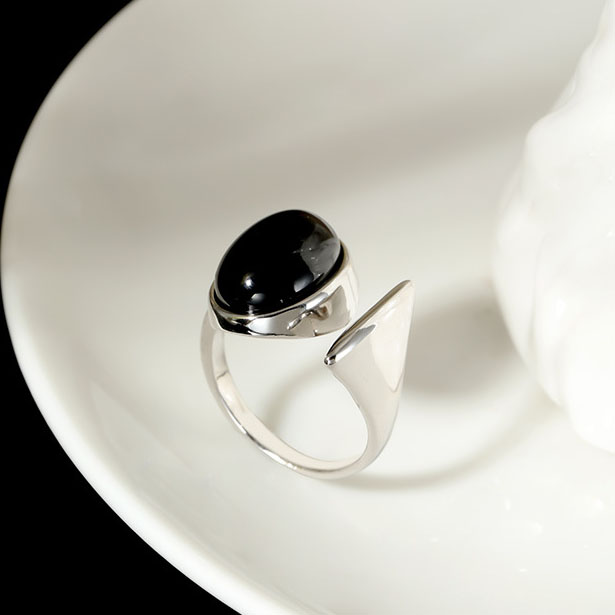 Overhead flat lay of Adjustable Onyx Geometric Ring on minimalist marble surface
