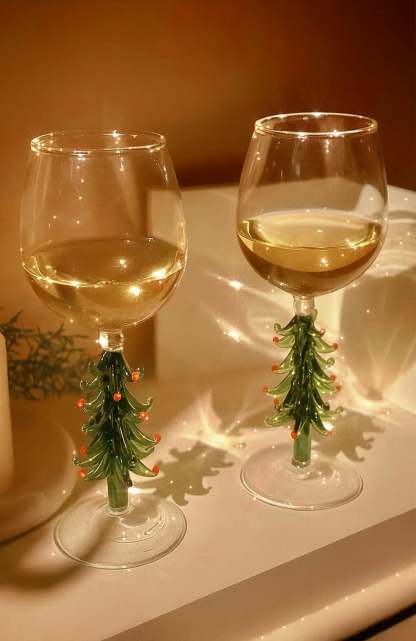 Two Merry Christmas Wine Flutes set among a soft fireplace glow.