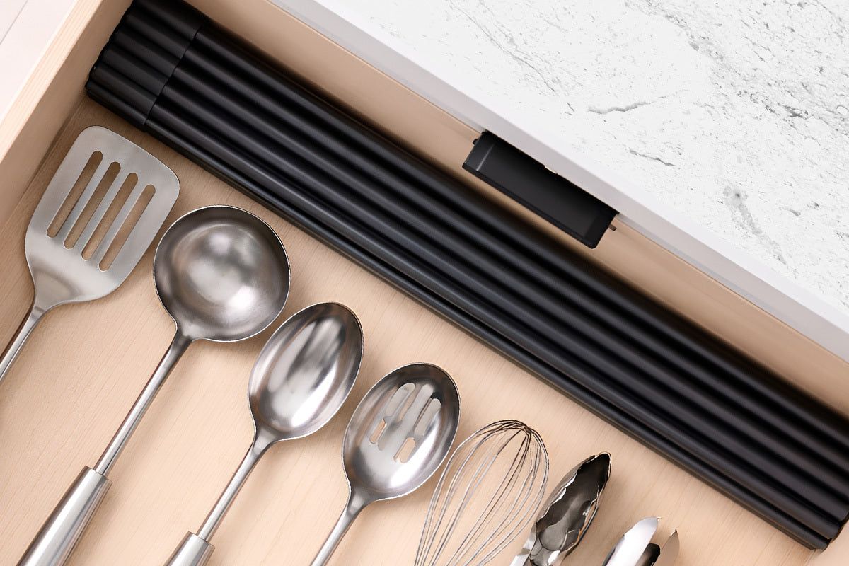 Set of kitchen utensils including spoons, spatula, and whisk in a drawer.