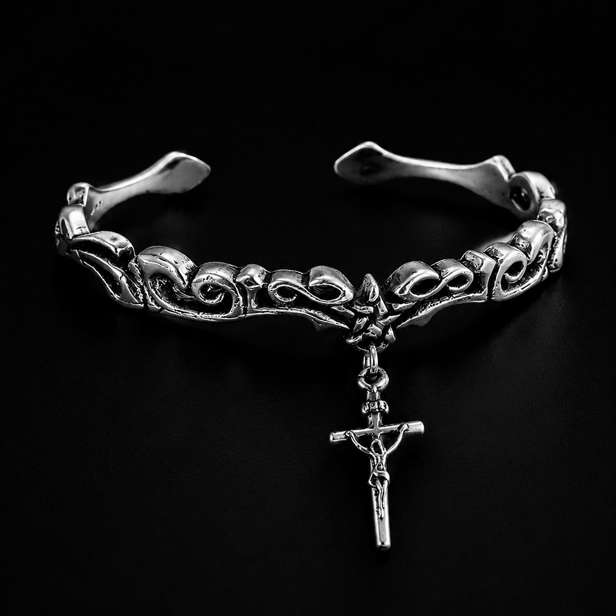 The vine-motif cross bracelet blends Gothic craftsmanship with timeless symbolism.