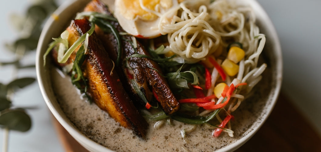bowl of coconut ramen with aromatics and fresh vegetables
