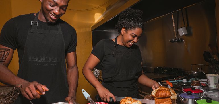 2 people in the kitchen enjoying cooking food together