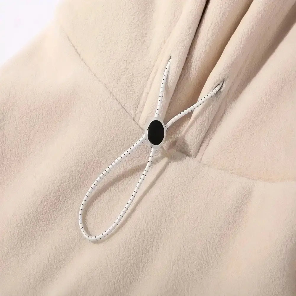 Close-up of a black button on a beige fabric background