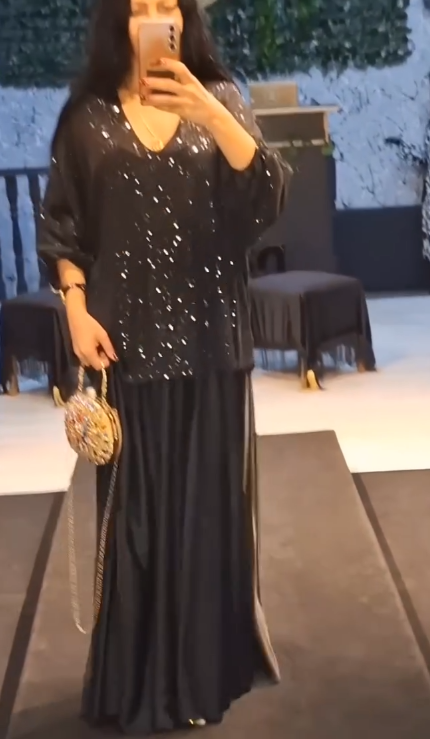 Strój składający się z koszuli z cekinami i długiej, zwiewnej, eleganckiej spódnicy.