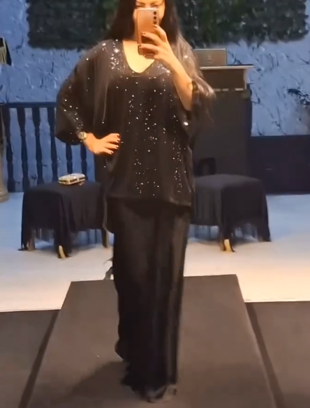 Strój składający się z koszuli z cekinami i długiej, zwiewnej, eleganckiej spódnicy.