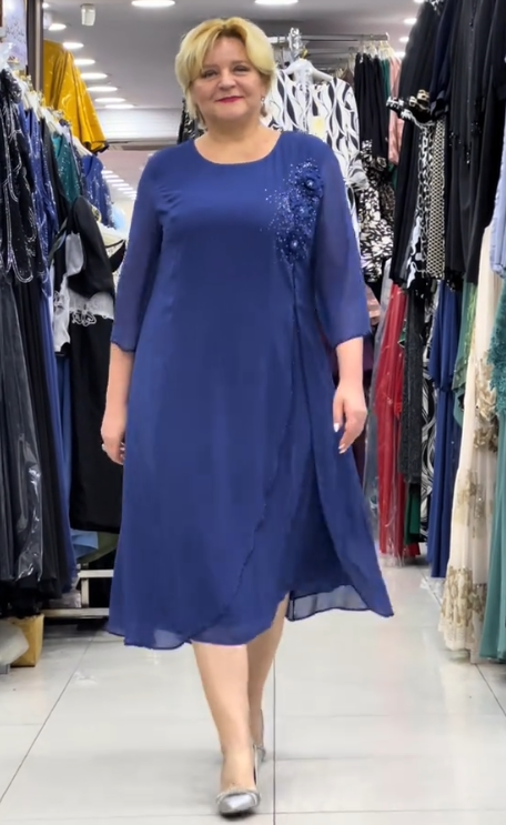 Prosta sukienka z okrągłym dekoltem, rękawami do kolan i wyjątkowymi zdobieniami z cekinów na ramionach.