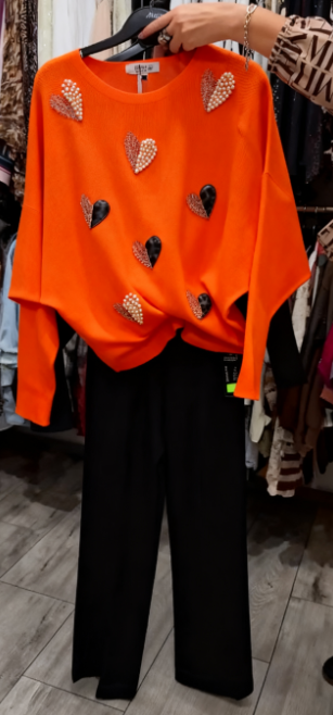 Marynarka ozdobiona wzorem w serca, zestawiona z czarnymi spodniami.