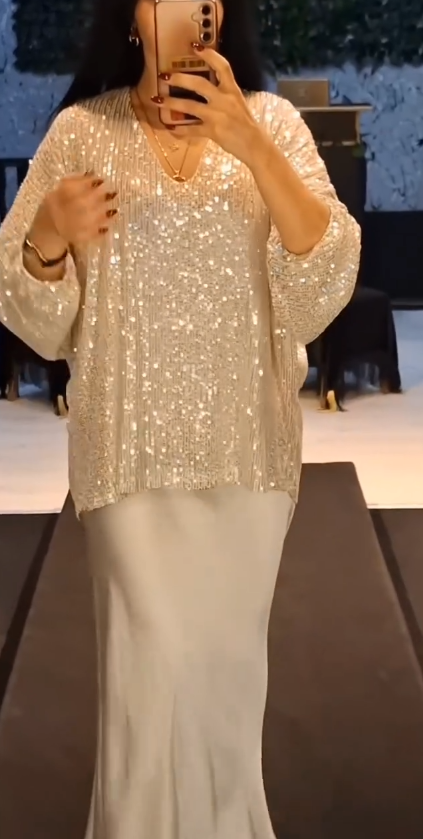 Strój składający się z koszuli z cekinami i długiej, zwiewnej, eleganckiej spódnicy.