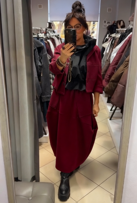 Płaszcz z kapeluszem i długą, luźną spódnicą z dużymi kieszeniami.