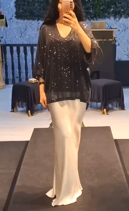 Strój składający się z koszuli z cekinami i długiej, zwiewnej, eleganckiej spódnicy.