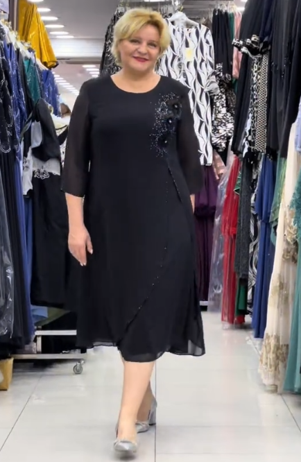 Prosta sukienka z okrągłym dekoltem, rękawami do kolan i wyjątkowymi zdobieniami z cekinów na ramionach.