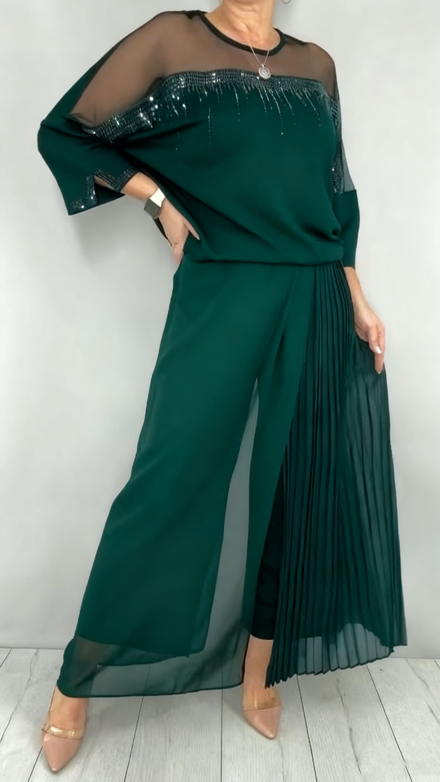 Garnitur z przezroczystym tiulem i cekinami na rękawach i dekolcie oraz plisowanymi panelami na spodniach.