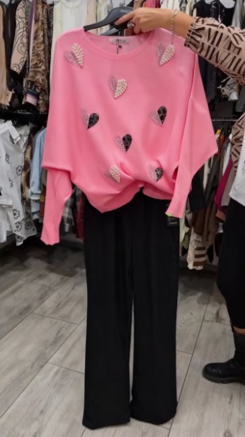 Marynarka ozdobiona wzorem w serca, zestawiona z czarnymi spodniami.