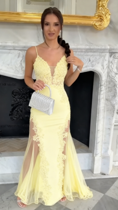 Sukienka na ramiączkach typu spaghetti z głębokim dekoltem w serek i wysokim rozcięciem, wykonana z półprzezroczystego materiału i ozdobiona aplikacjami.