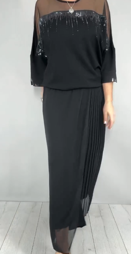 Garnitur z przezroczystym tiulem i cekinami na rękawach i dekolcie oraz plisowanymi panelami na spodniach.