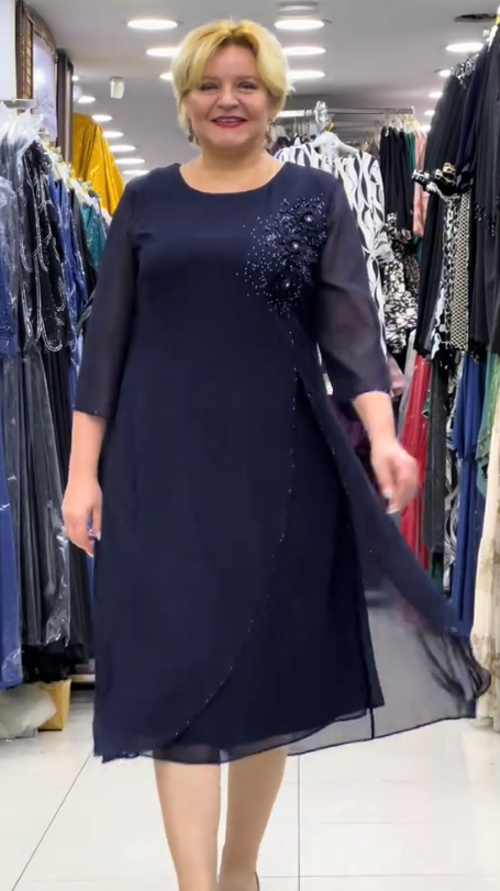 Prosta sukienka z okrągłym dekoltem, rękawami do kolan i wyjątkowymi zdobieniami z cekinów na ramionach.