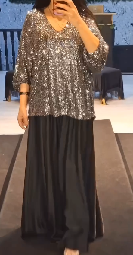 Strój składający się z koszuli z cekinami i długiej, zwiewnej, eleganckiej spódnicy.