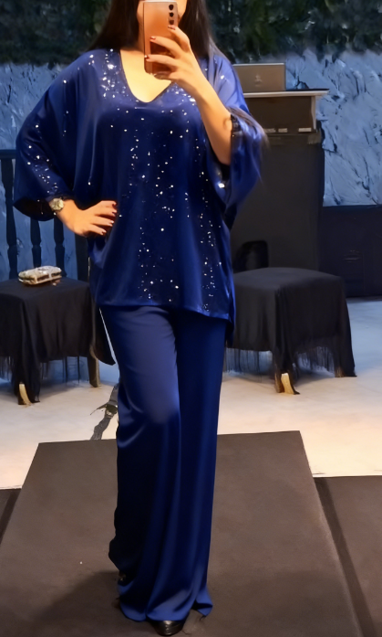 Strój składający się z koszuli z cekinami i długiej, zwiewnej, eleganckiej spódnicy.