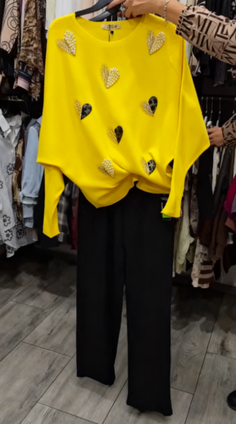 Marynarka ozdobiona wzorem w serca, zestawiona z czarnymi spodniami.