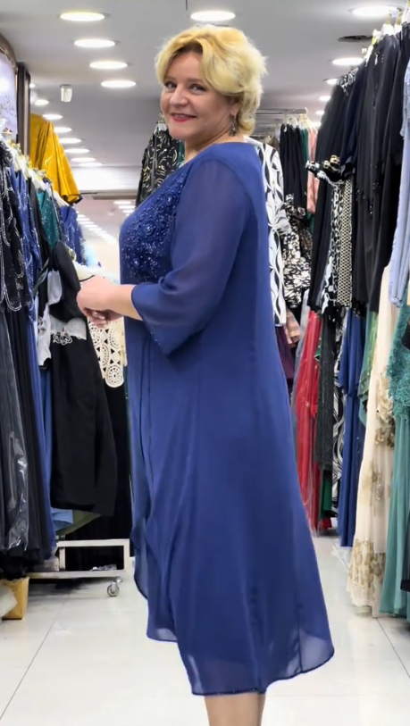 Prosta sukienka z okrągłym dekoltem, rękawami do kolan i wyjątkowymi zdobieniami z cekinów na ramionach.