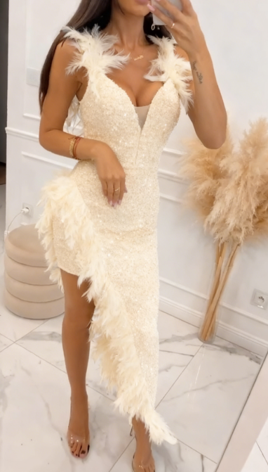 Asymetryczna sukienka z dekoltem w serek, pokryta cekinami, ze wzorami z piór na ramionach i dole.