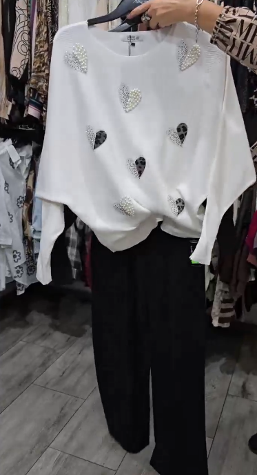 Marynarka ozdobiona wzorem w serca, zestawiona z czarnymi spodniami.