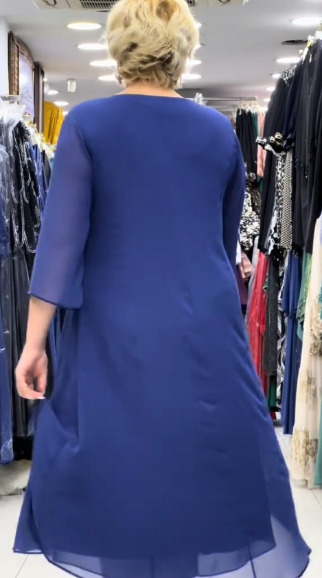 Prosta sukienka z okrągłym dekoltem, rękawami do kolan i wyjątkowymi zdobieniami z cekinów na ramionach.