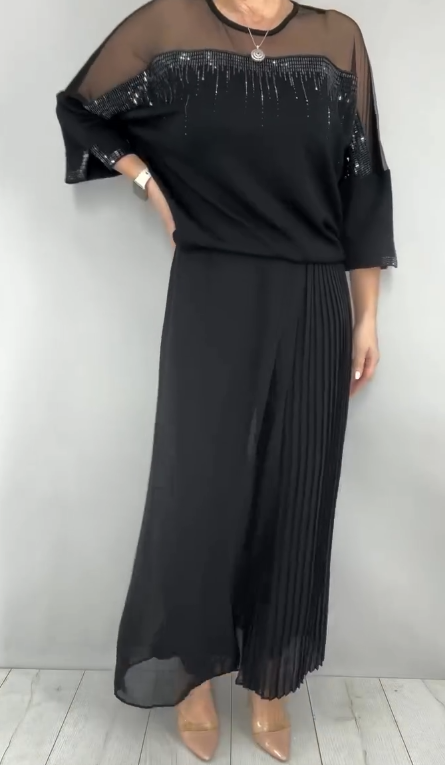 Garnitur z przezroczystym tiulem i cekinami na rękawach i dekolcie oraz plisowanymi panelami na spodniach.