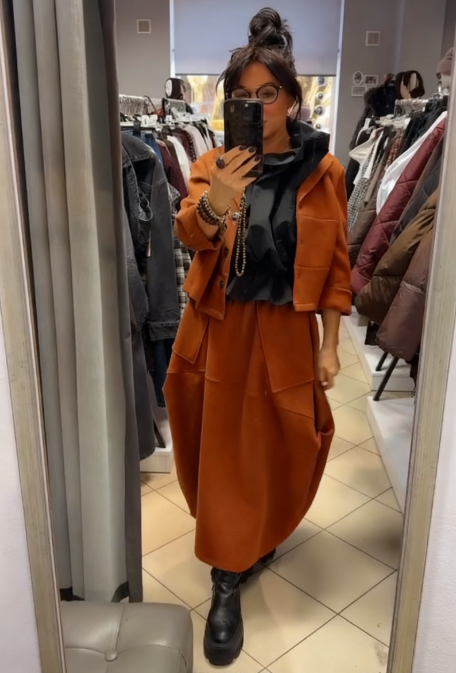 Płaszcz z kapeluszem i długą, luźną spódnicą z dużymi kieszeniami.