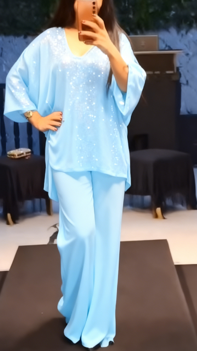 Strój składający się z koszuli z cekinami i długiej, zwiewnej, eleganckiej spódnicy.