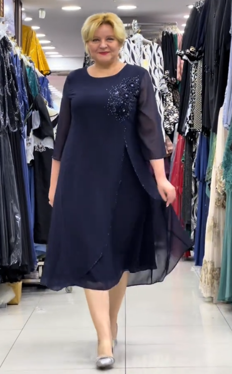 Prosta sukienka z okrągłym dekoltem, rękawami do kolan i wyjątkowymi zdobieniami z cekinów na ramionach.