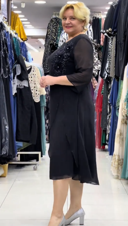 Prosta sukienka z okrągłym dekoltem, rękawami do kolan i wyjątkowymi zdobieniami z cekinów na ramionach.