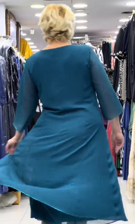 Prosta sukienka z okrągłym dekoltem, rękawami do kolan i wyjątkowymi zdobieniami z cekinów na ramionach.