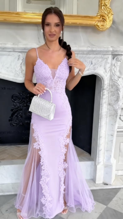 Sukienka na ramiączkach typu spaghetti z głębokim dekoltem w serek i wysokim rozcięciem, wykonana z półprzezroczystego materiału i ozdobiona aplikacjami.