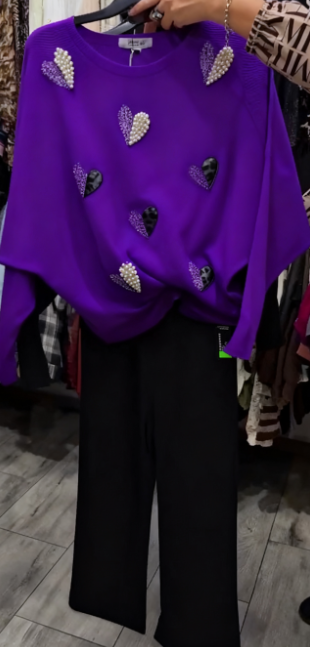 Marynarka ozdobiona wzorem w serca, zestawiona z czarnymi spodniami.