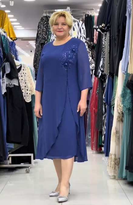 Prosta sukienka z okrągłym dekoltem, rękawami do kolan i wyjątkowymi zdobieniami z cekinów na ramionach.