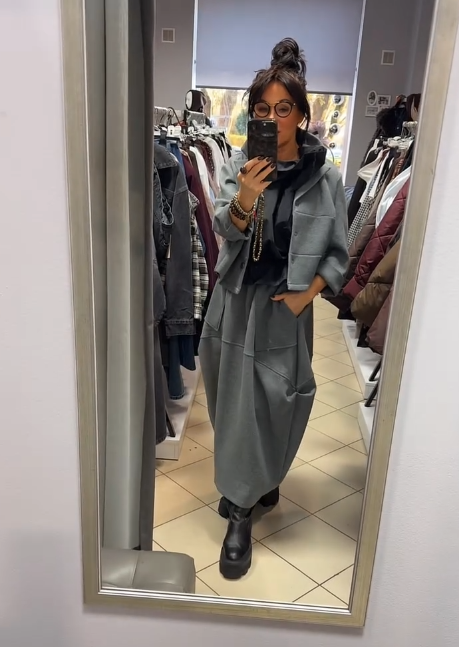 Płaszcz z kapeluszem i długą, luźną spódnicą z dużymi kieszeniami.