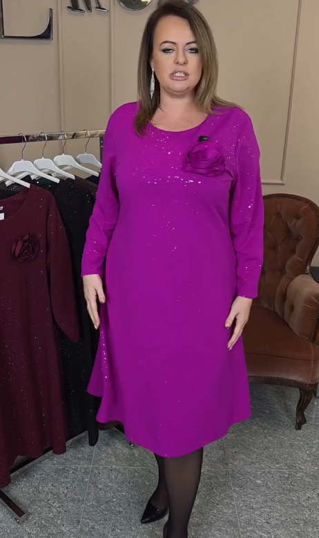 Elegancka sukienka z okrągłym dekoltem ozdobiona cekinami i kwiatowymi aplikacjami.