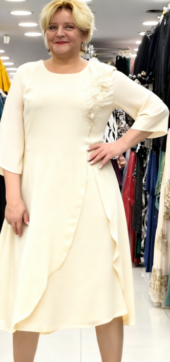 Prosta sukienka z okrągłym dekoltem, rękawami do kolan i wyjątkowymi zdobieniami z cekinów na ramionach.